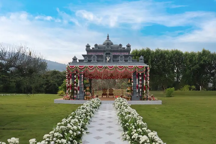 A floral wedding mandap against an ornate palace backdrop